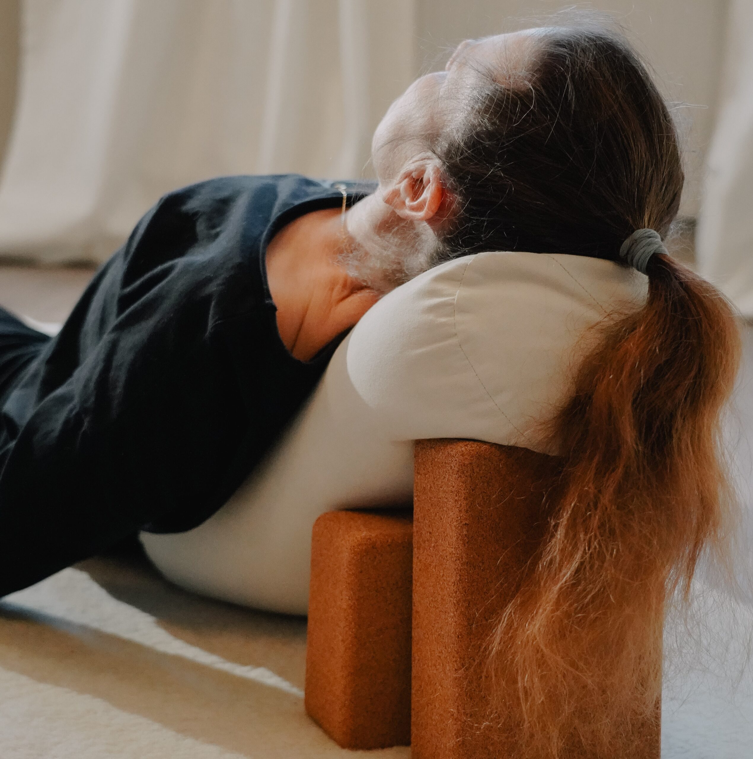 Kvinna som vilar i en yinyogaposition i en lugn miljö, yinyoga hos OnLife i Järfälla.